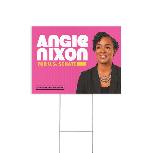 Pink rectangular yard sign with bold white text "ANGIE NIXON" and yellow text "FOR U.S.