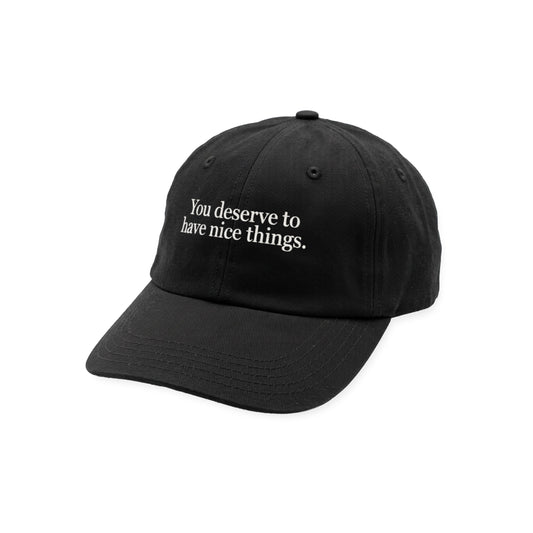 Black cotton dad hat with curved brim, white embroidered text "You deserve to have nice things." on front.